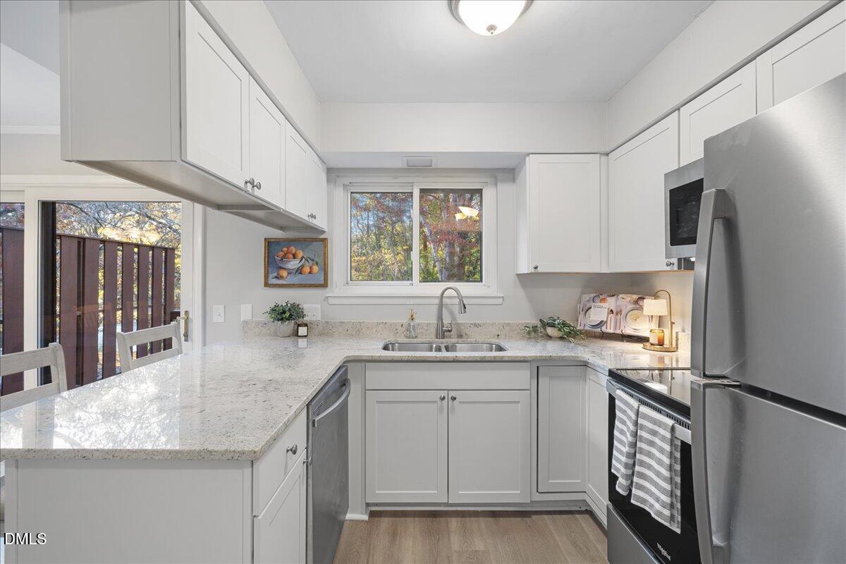 5821 Mapleridge Road Raleigh, NC 27609 - Photo 11 of 38 a kitchen with a sink stove and cabinets