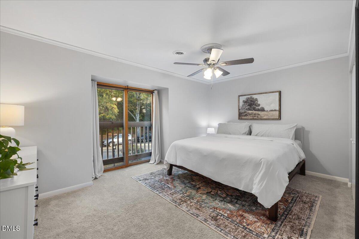 5821 Mapleridge Road Raleigh, NC 27609 - Photo 19 of 38 a bedroom with a large bed and a chandelier