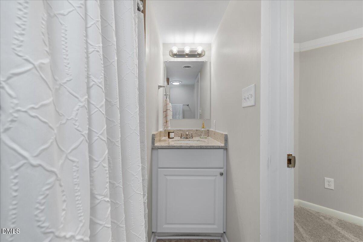 5821 Mapleridge Road Raleigh, NC 27609 - Photo 31 of 38 a bathroom with a granite countertop sink and a mirror