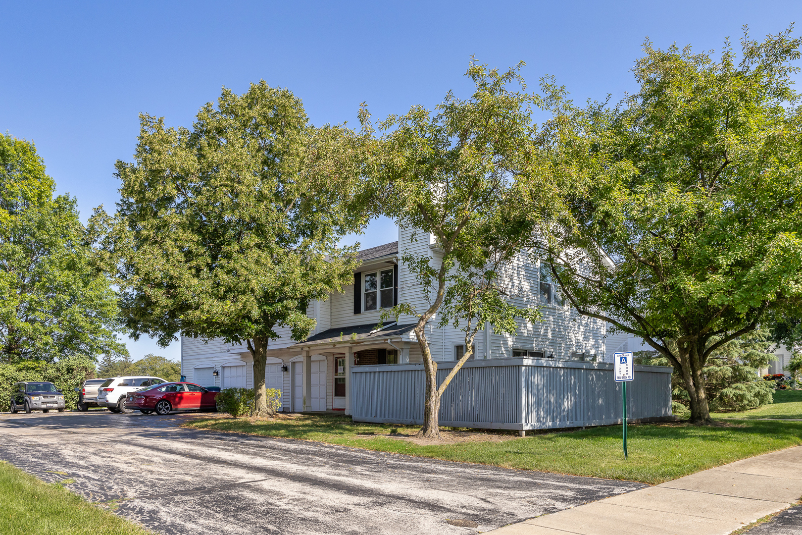 a front view of a house with a garden and tree