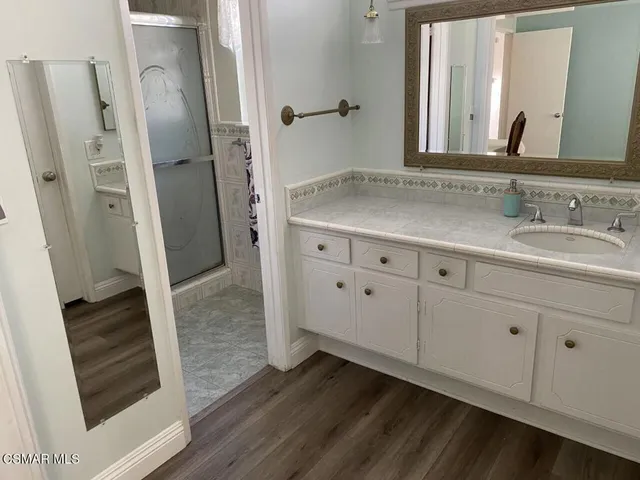 a bathroom with a granite countertop sink and a mirror