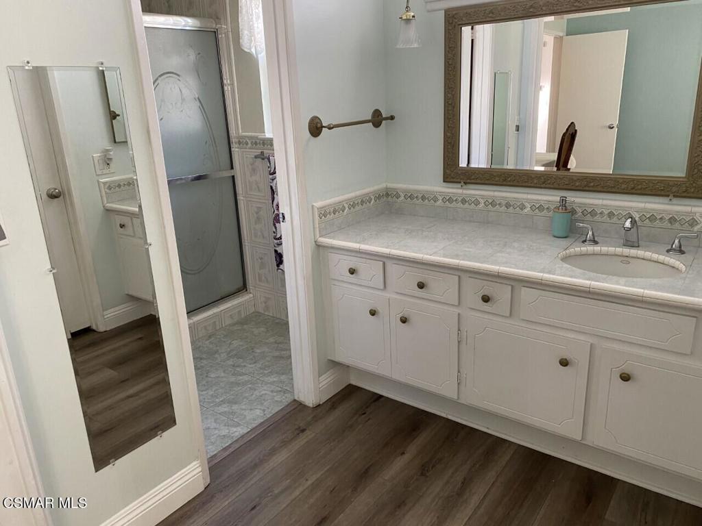 652 Harper Street Simi Valley, CA 93065 - Photo 22 of 27 a bathroom with a granite countertop sink and a mirror