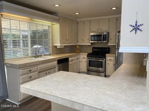 a kitchen with stainless steel appliances kitchen island granite countertop a stove a sink and a microwave