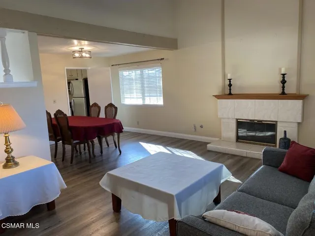 a living room with furniture a dining table and a fireplace