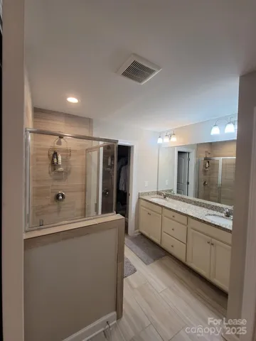 a large bathroom with a double vanity sink a mirror and a bathtub