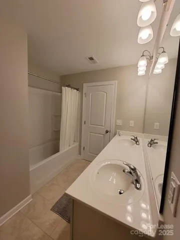 a bathroom with a sink a tub and a mirror