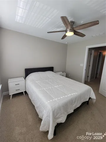 a bedroom with a bed and a ceiling fan