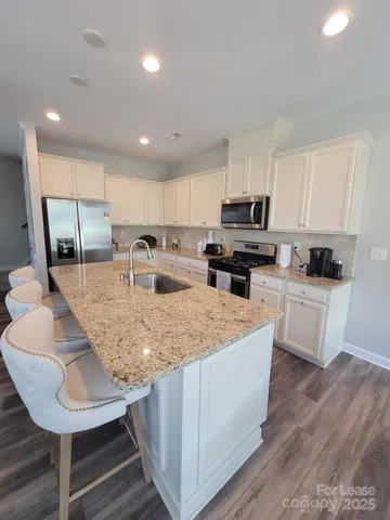 a kitchen with kitchen island granite countertop a sink counter top space and cabinets