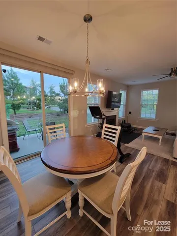 a dining room with furniture a chandelier and wooden floor