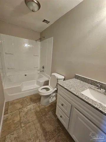 a spacious bathroom with a granite countertop sink a toilet and bathtub