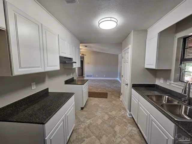 a kitchen with a sink stove and cabinets