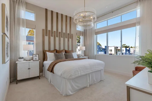 a spacious bedroom with a bed and a chandelier