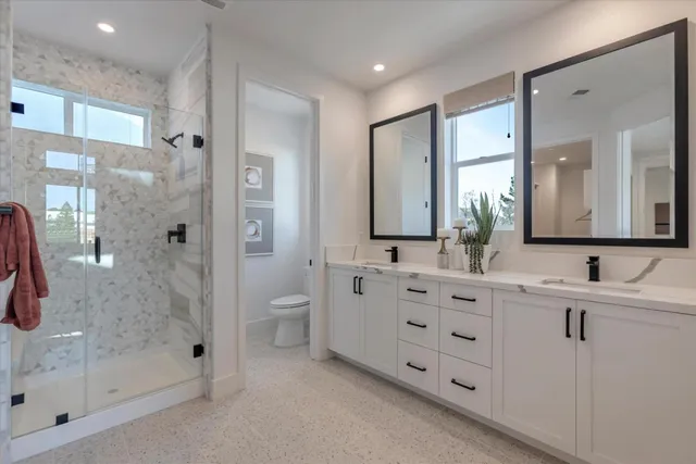 a bathroom with a double vanity sink mirror and shower