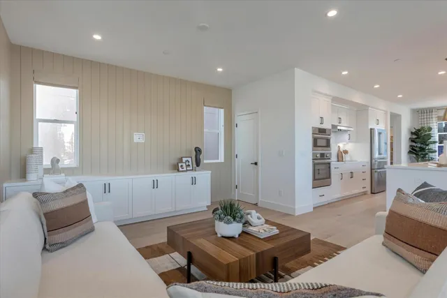 a living room with furniture and view of kitchen