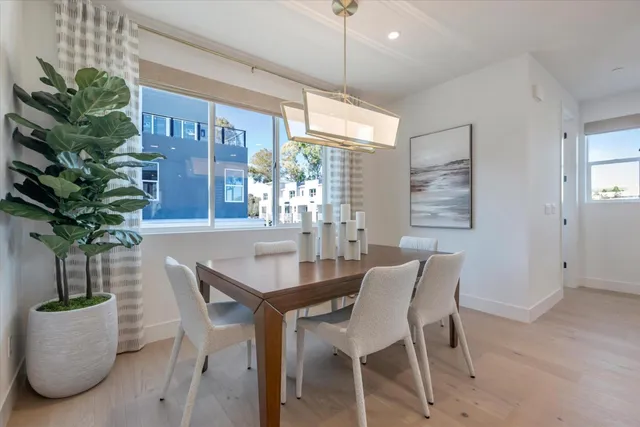 a dining room with furniture potted plants and wooden floor