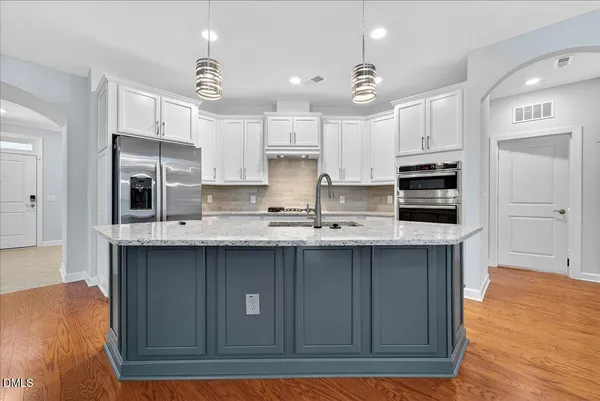 a kitchen with stainless steel appliances granite countertop a sink stove and refrigerator
