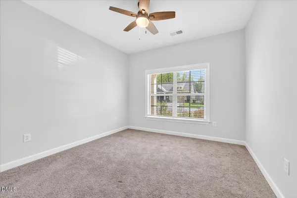 an empty room with chandelier fan
