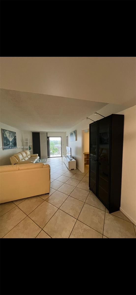 8255 Abbott Avenue, Unit 402 Miami Beach, FL 33141 - Photo 20 of 32 a living room with a couch and a night stand