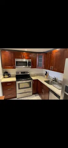 a view of kitchen with stainless steel appliances a stove and cabinets