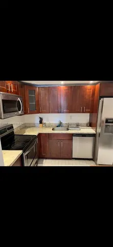 a view of kitchen island with kitchen island sink refrigerator and stove