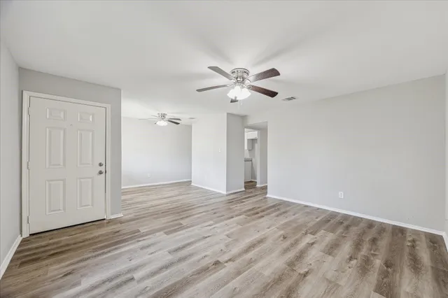 a view of an empty room with wooden floor