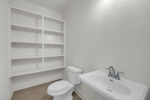 a kitchen with stainless steel appliances granite countertop a refrigerator a sink dishwasher a stove and a dining table with wooden floor