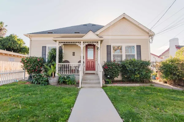 a front view of a house with a yard and trees