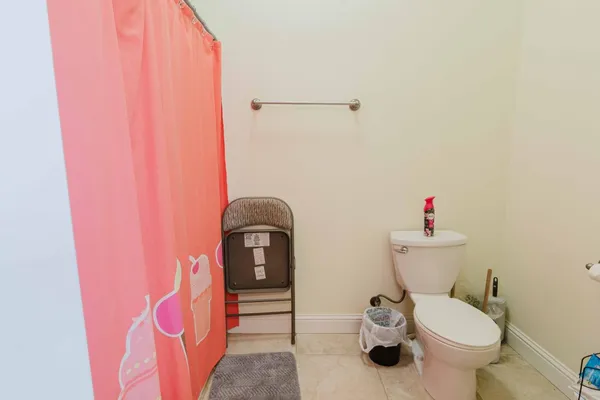 a bathroom with a toilet and a shower curtain