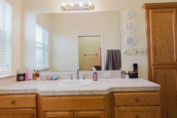 a bathroom with a granite countertop sink and a mirror