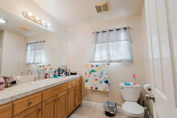 a bathroom with a sink mirror vanity and toilet