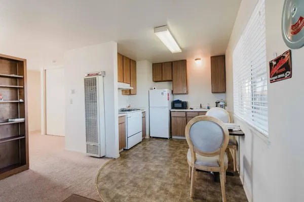 a view of kitchen with refrigerator stove dining table and chairs
