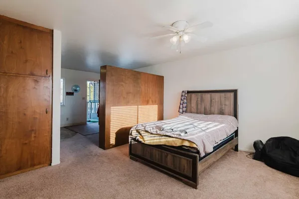 a spacious bedroom with a bed and a chandelier