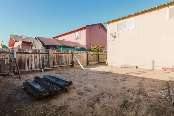 a view of a backyard with wooden fence