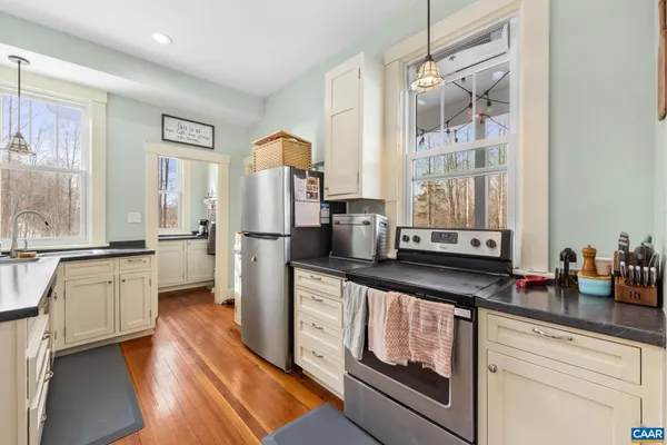 a large kitchen with stainless steel appliances granite countertop a lot of counter space and a wooden floors