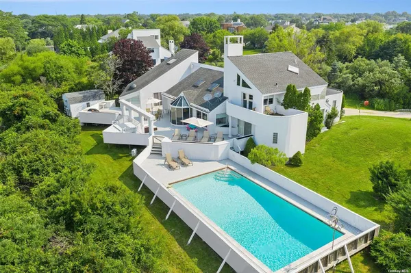 an aerial view of a house with pool garden and plants