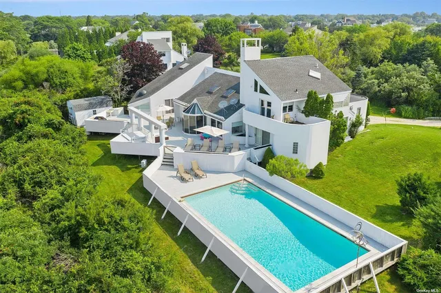 an aerial view of a house with pool garden and plants