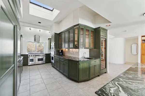 a kitchen with stainless steel appliances kitchen island granite countertop a refrigerator and a stove