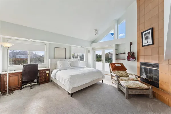 a bedroom with a bed chair and fireplace