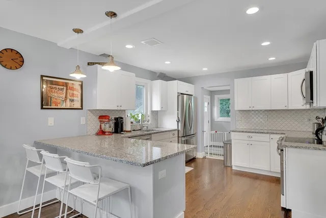 a kitchen with stainless steel appliances granite countertop a sink refrigerator and cabinets