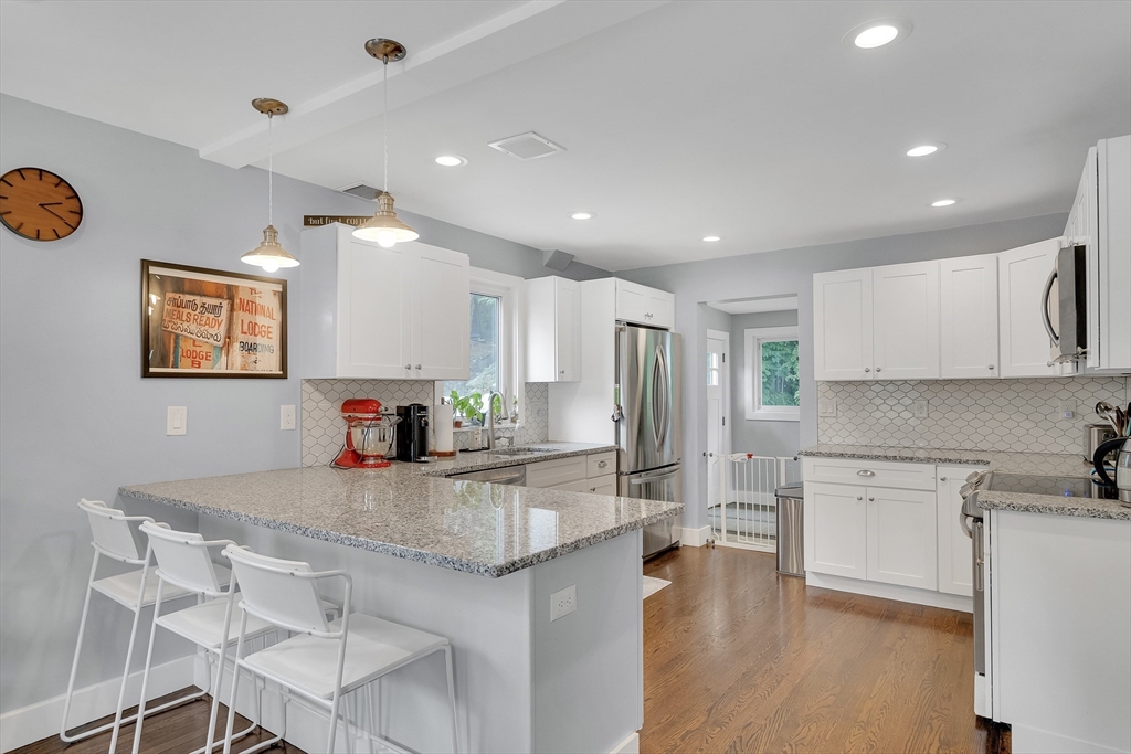 103 Stimson Street Boston, MA 02132 - Photo 4 of 10 a kitchen with stainless steel appliances granite countertop a sink refrigerator and cabinets