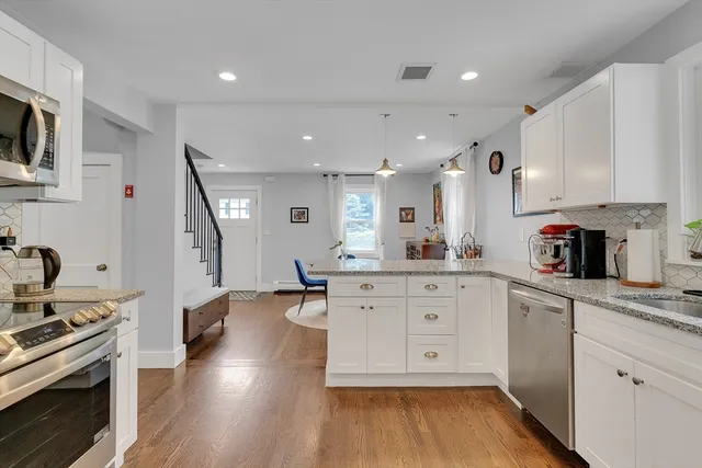 a large kitchen with cabinets wooden floor and stainless steel appliances