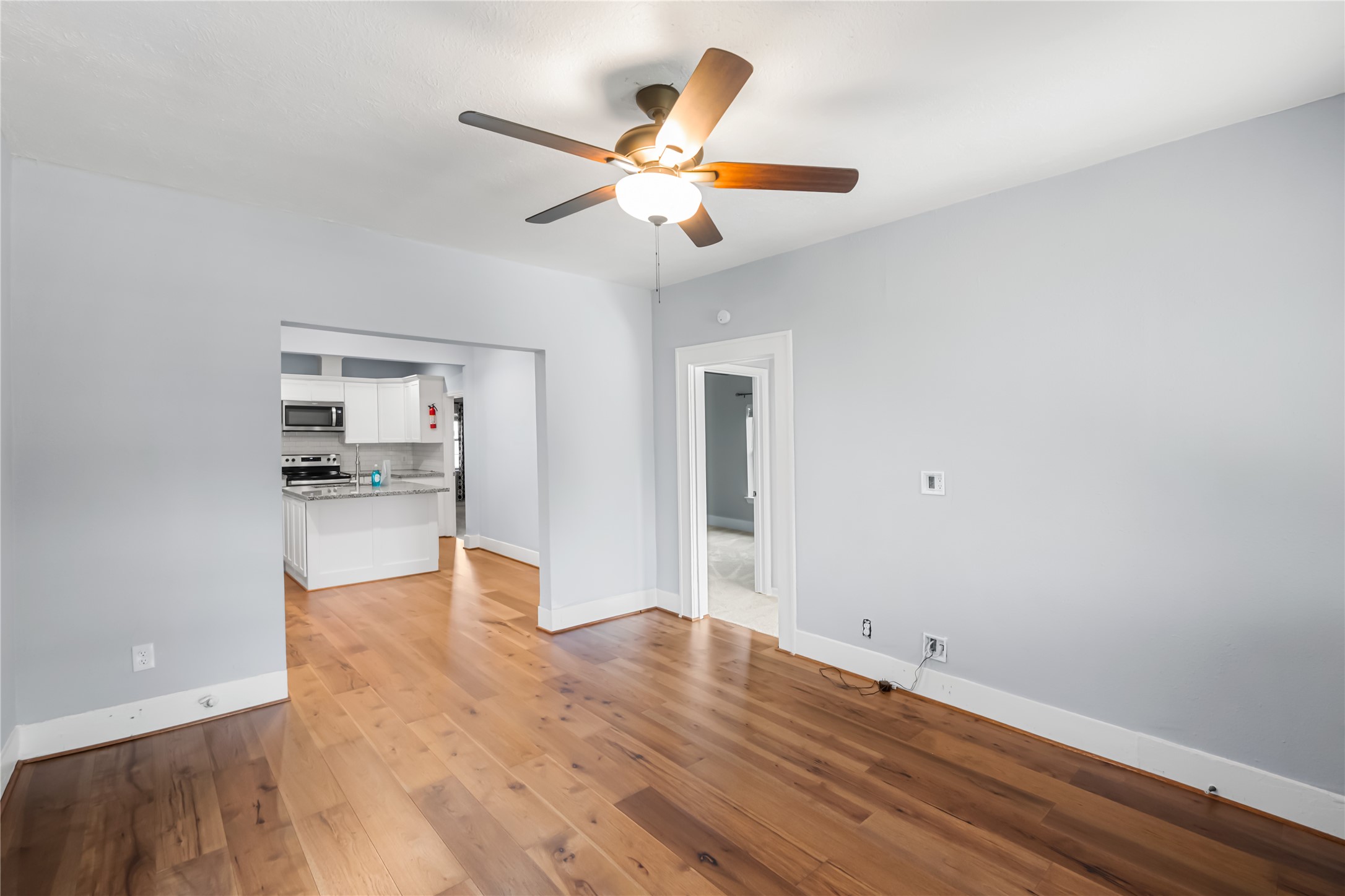 3108 Indiana Street Baytown, TX 77520 - Photo 4 of 20 a view of a livingroom with wooden floor and a ceiling fan