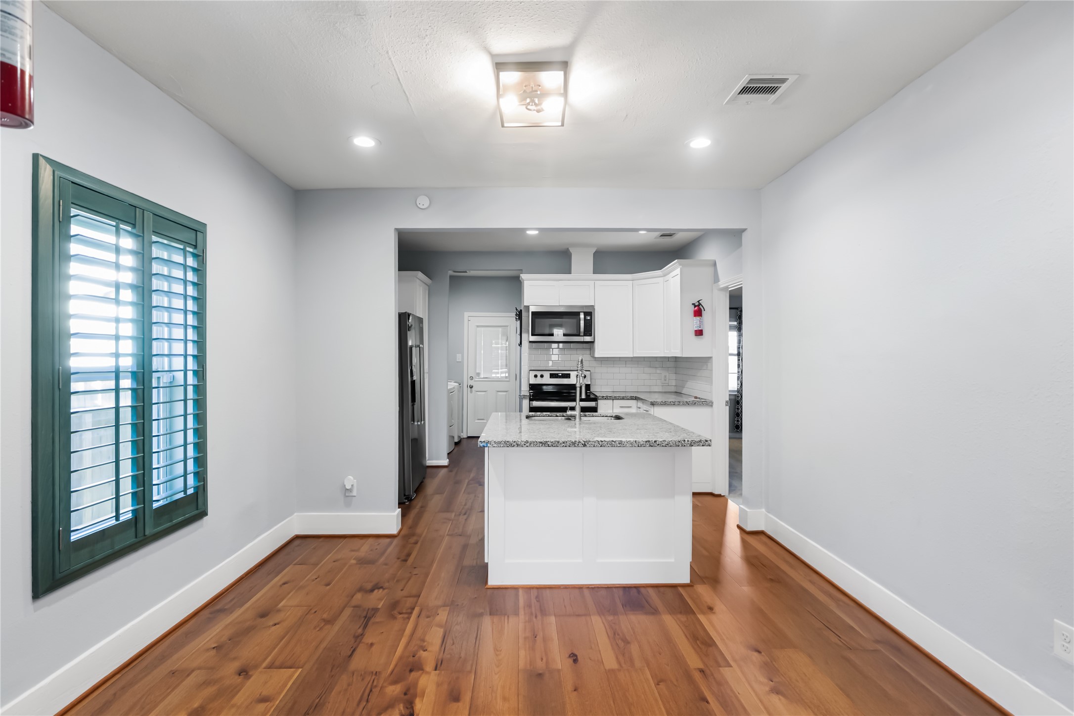 3108 Indiana Street Baytown, TX 77520 - Photo 5 of 20 a kitchen with white cabinets and wooden floor