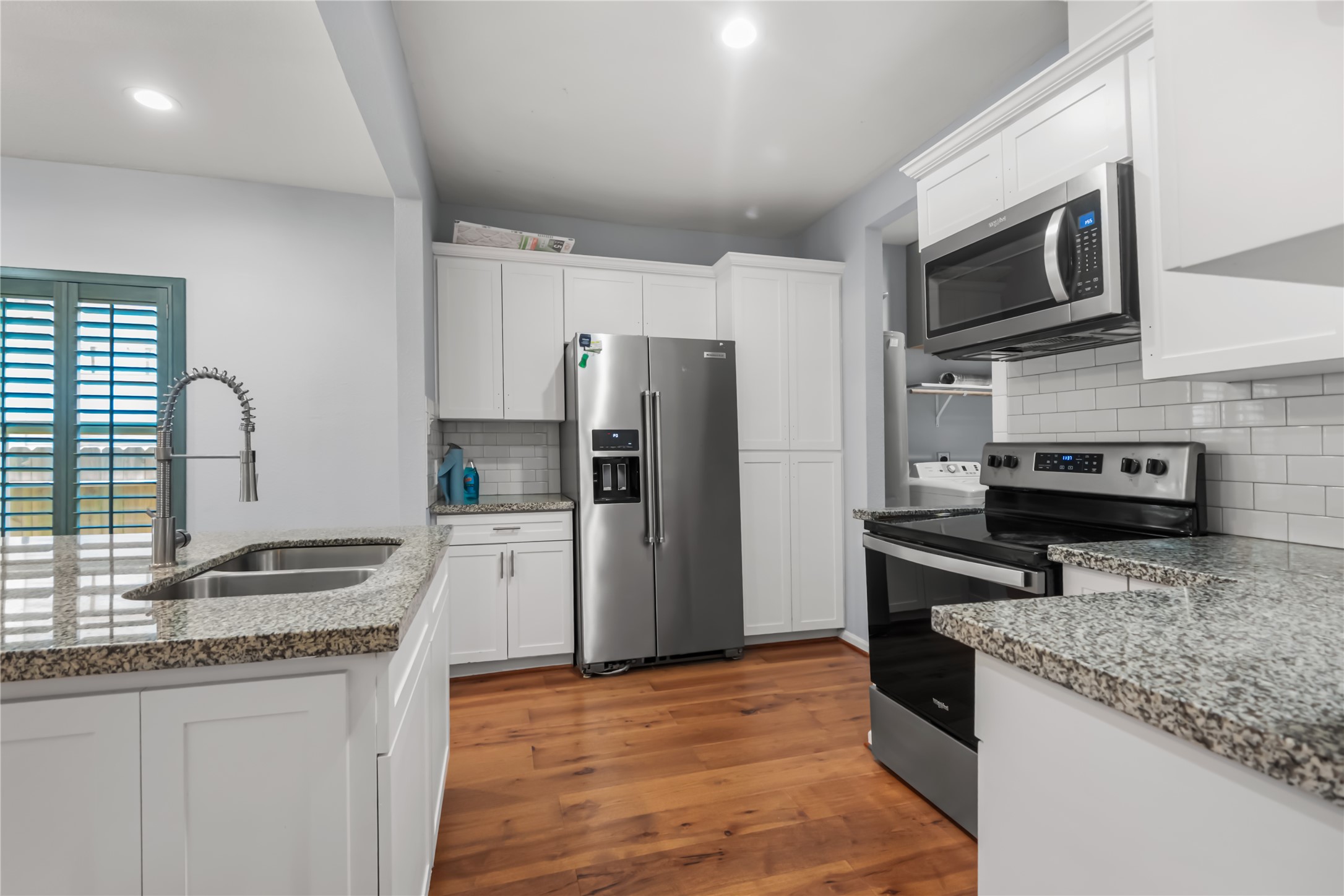 3108 Indiana Street Baytown, TX 77520 - Photo 7 of 20 a kitchen with granite countertop a refrigerator stove and microwave