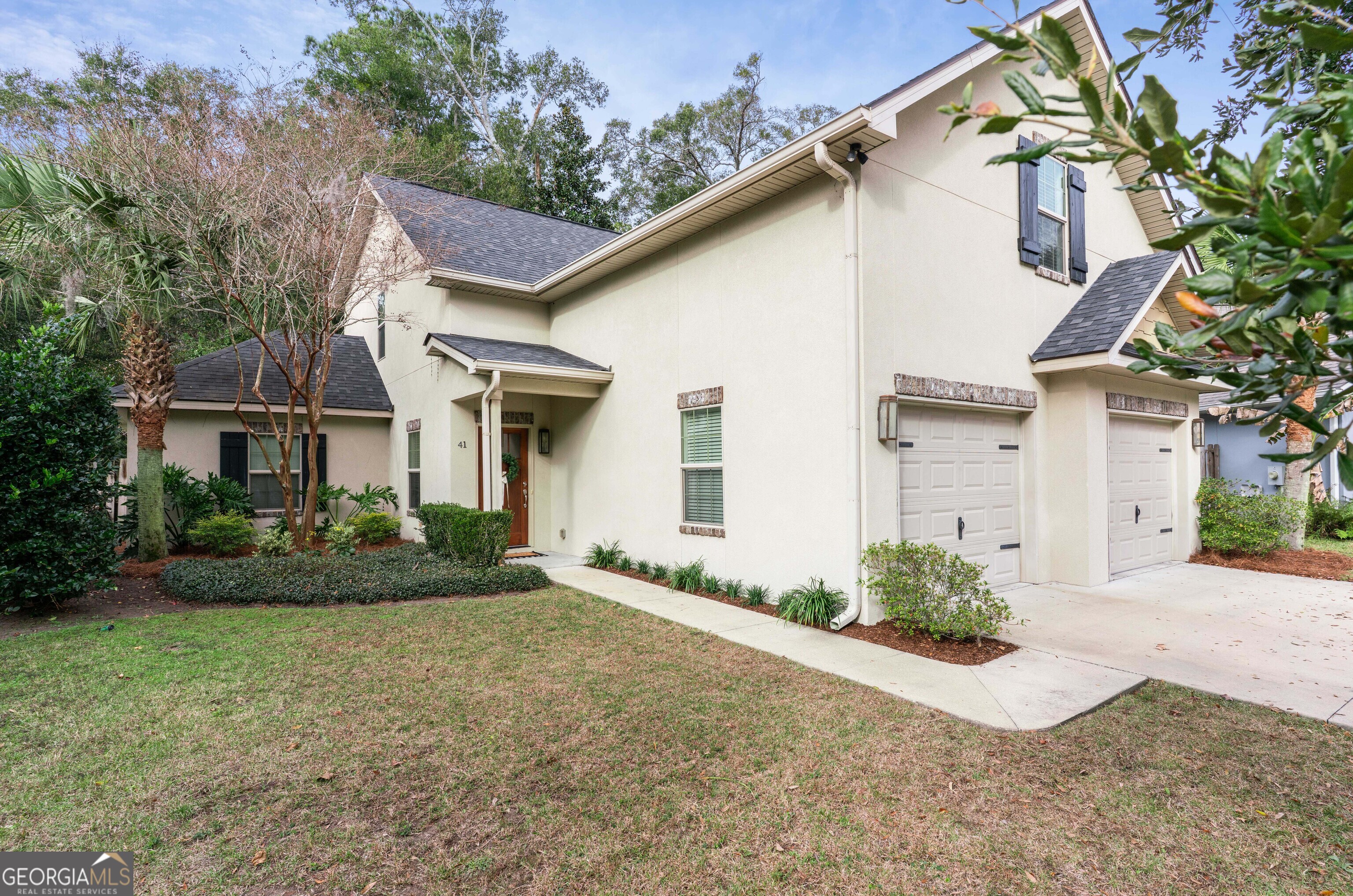 41 Simonton Lane St. Simons Island, GA 31522 - Photo 2 of 28 a view of a white house with a yard and plants