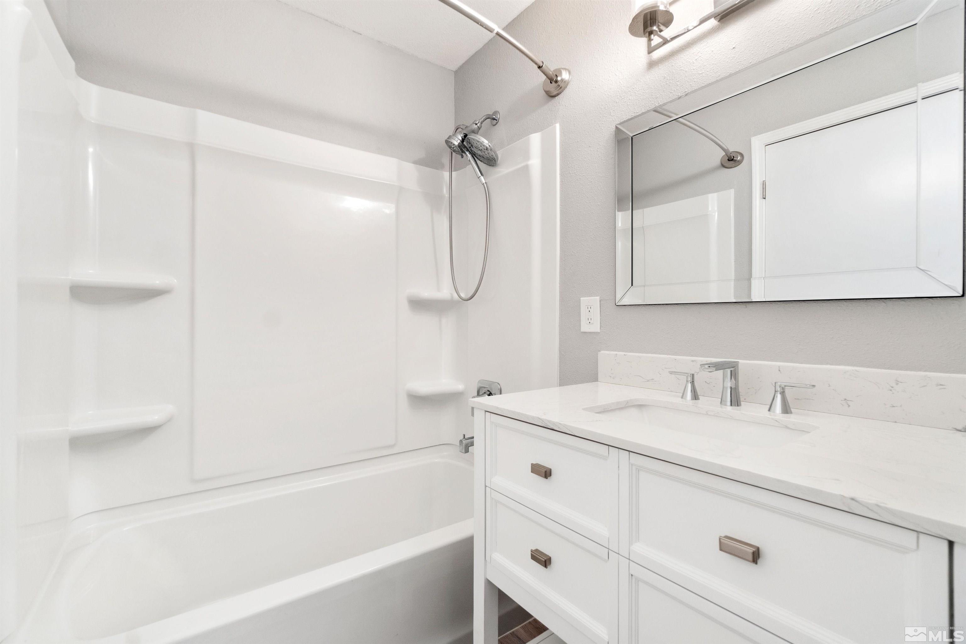 29 Condor Circle Carson City, NV 89701 - Photo 23 of 28 a bathroom with a sink vanity granite tub shower and a mirror