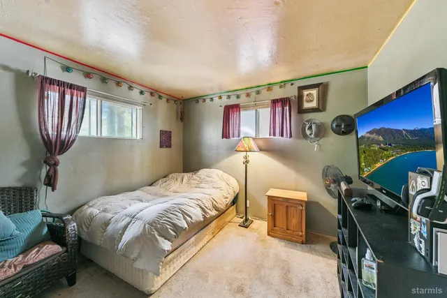 a bedroom with a bed next to a window with the outer view