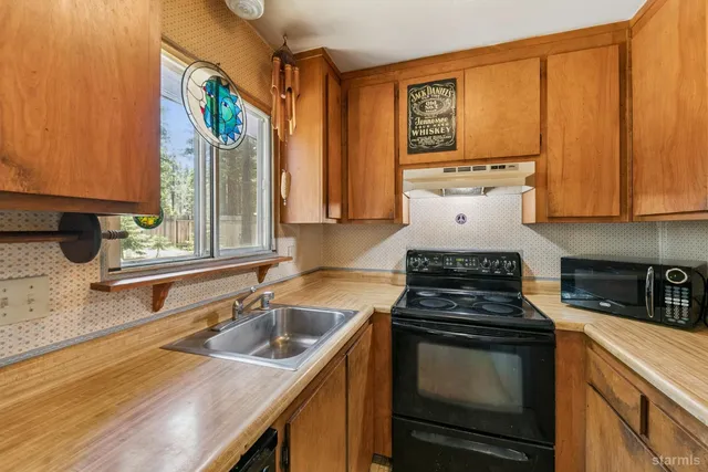 a kitchen with stainless steel appliances a stove a sink and a microwave