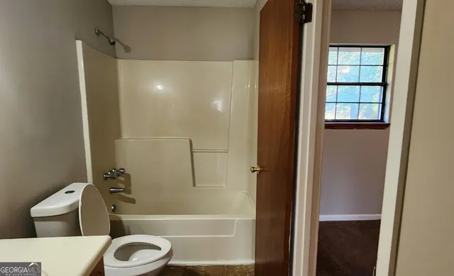 a bathroom with a toilet and a shower
