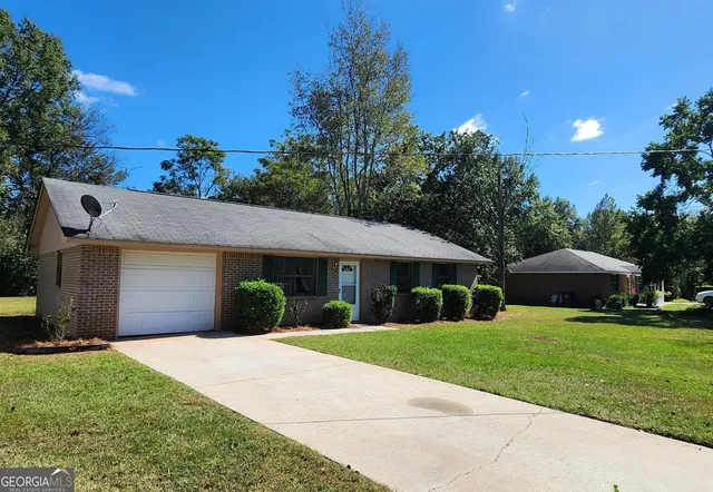 a front view of a house with yard and green space